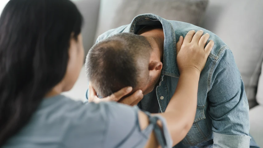 Man receiving emotional support from a woman